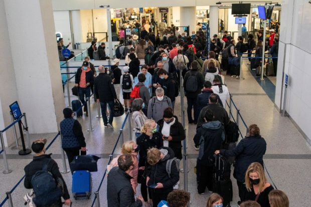 Passengers wait in line inside the terminal at Newark Liberty International Airport in Newark, New Jersey, U.S., November 24, 2021. REUTERS/Eduardo Munoz/File Photo