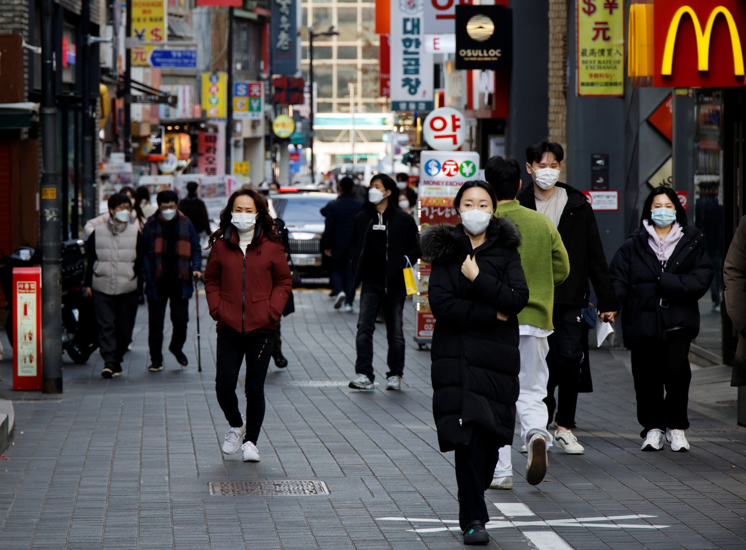 FILE PHOTO: People wearing masks walk in a shopping district amid the coronavirus disease (COVID-19) pandemic in Seoul, South Korea, November 29, 2021. REUTERS/Heo Ran