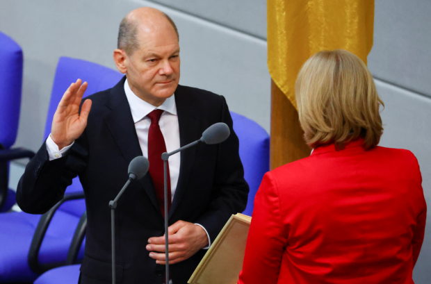 Newly elected German Chancellor Olaf Scholz is sworn-in by Parliament President Baerbel Bas during a session of the German lower house of parliament Bundestag, in Berlin, Germany, December 8, 2021. REUTERS/Fabrizio Bens