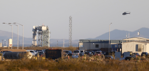 A helicopter hovers near the Blue Origin New Shepard rocket before it's scheduled lift off  in West Texas
