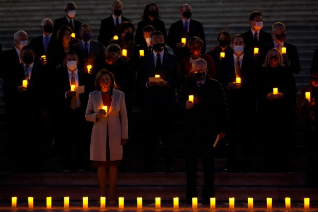 Bipartisan members of the House and Senate, including House Speaker Nancy Pelosi (D-CA) and U.S. Senate Majority Leader Chuck Schumer (D-NY), gather to hold a moment of silence for the more than 800,000 American lives lost to COVID-19 outside the U.S. Capitol building in Washington, U.S., December 14, 2021. REUTERS/Elizabeth Frantz