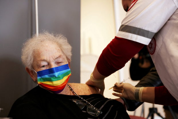 FILE PHOTO: A elderly woman receives a booster shot of her vaccination against the coronavirus disease (COVID-19) at an assisted living facility, in Netanya, Israel January 19, 2021. REUTERS/Ronen Zvulun