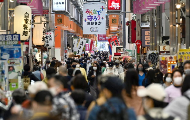 FILE PHOTO: Pedestrians wearing protective face masks, amid the coronavirus disease (COVID-19) pandemic, are seen at a shopping district in Osaka, Japan, in this photo taken by Kyodo April 7, 2021. Mandatory credit Kyodo/via REUTERS