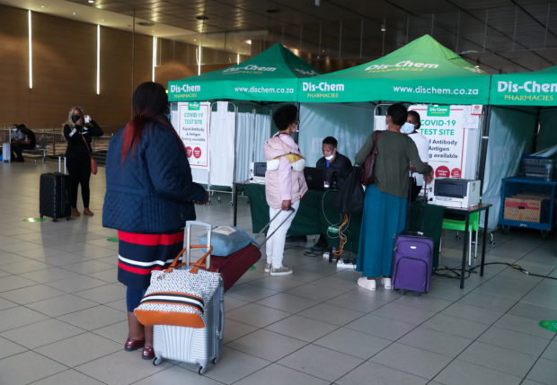 FILE PHOTO: Passengers queue to get a PCR test against the coronavirus disease (COVID-19) before traveling on international flights, at O.R. Tambo International Airport in Johannesburg, South Africa, November 26, 2021. REUTERS/Sumaya Hisham