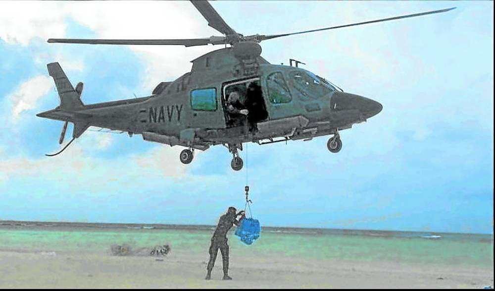A Philippine Navy chopper drops Christmas packages for soldiers deployed in the West Philippine Sea.