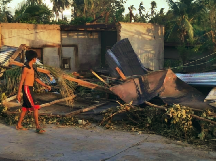 A Glance at the Ruins. A child walked past a destroyed house in Compostela, one of the badly hit areas in the Northern Cebu.