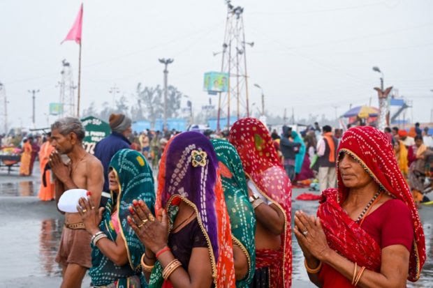 Pilgrims perform rituals as they pray at the beach during the Hindu religious festival of Gangasagar Mela on Sagar Island, some 150 kilometers south of Kolkata, West Bengal, on January 13, 2022. (Photo by Dibyangshu SARKAR / AFP)
