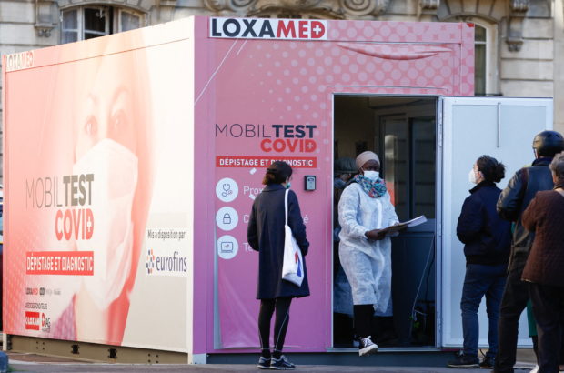 People queue at a mobile coronavirus disease (COVID-19) testing booth in Paris, France, December 31, 2021. REUTERS/Christian Hartmann