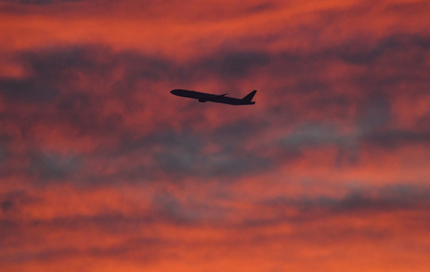 A plane is seen shortly after take-off at sunset, from Heathrow Airport, London