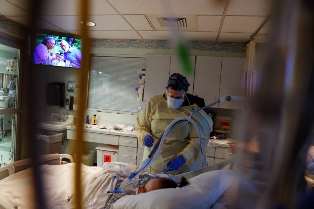 Medical staff treat a coronavirus disease (COVID-19) patient in their isolation room on the Intensive Care Unit (ICU) at Western Reserve Hospital in Cuyahoga Falls, Ohio, U.S., January 5, 2022.  REUTERS/Shannon Stapleton