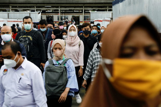 FILE PHOTO: People wearing protective masks walk through a platform of a train station during the afternoon rush hours as the Omicron variant continues to spread, amid the coronavirus disease (COVID-19) pandemic, in Jakarta, Indonesia, January 3, 2022. REUTERS/Willy Kurniawan