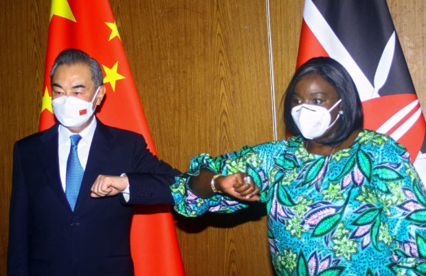 Chinese Foreign Minister Wang Yi and his Kenyan counterpart Raychelle Omamo bump elbows during a news conference in the coastal city of Mombasa, Kenya January 6, 2022. REUTERS/Joseph Okanga