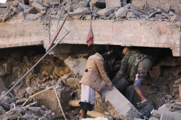 Rescuers search for survivors under the collapsed roof of a house hit by Saudi-led air strikes in Sanaa, Yemen, January 18, 2022. REUTERS/Khaled Abdullah