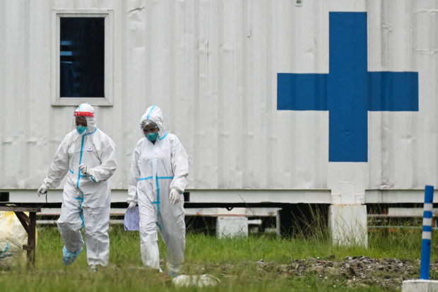 FILE PHOTO: Health workers in hazmat suits walk outside the Manila COVID-19 Field Hospital in Manila, Philippines, September 7, 2021. REUTERS/Lisa Marie David