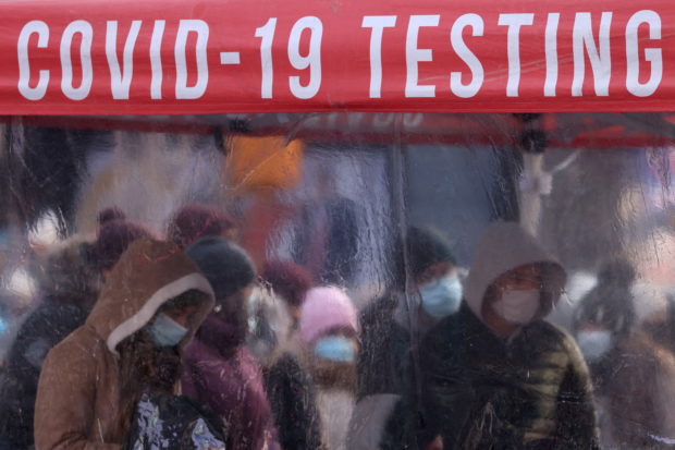 People queue to be tested for COVID-19 in Times Square, as the Omicron coronavirus variant continues to spread in Manhattan, New York City, U.S., December 20, 2021. REUTERS/Andrew Kelly     TPX IMAGES OF THE DAY