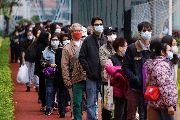 People queue up at a community testing centre for the coronavirus disease (COVID-19), after the district has been identified as a high-risk area, in Tuen Mun, Hong Kong, China, January 12, 2022. REUTERS/Tyrone Siu