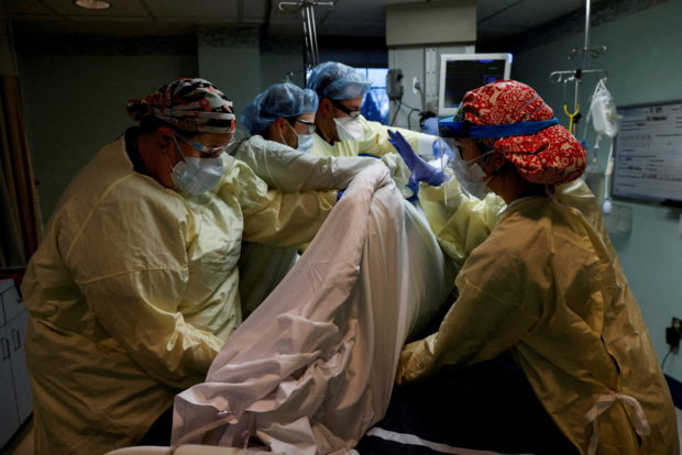 FILE PHOTO: Medical staff treat a coronavirus disease (COVID-19) patient in their isolation room on the Intensive Care Unit (ICU) at Western Reserve Hospital in Cuyahoga Falls, Ohio, U.S., January 4, 2022. REUTERS/Shannon Stapleton