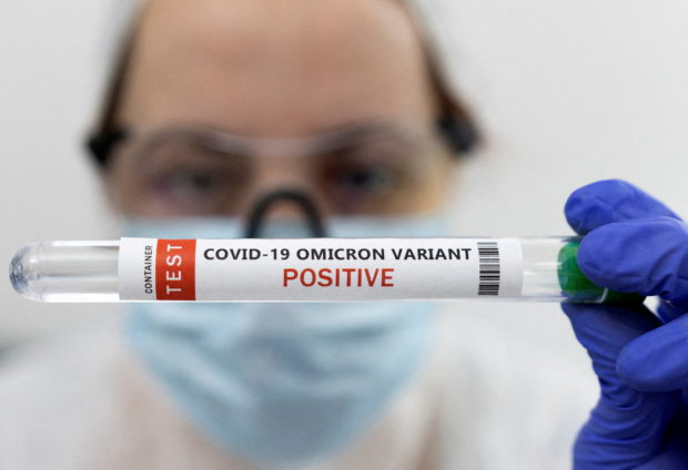 Test tube labeled "COVID-19 Omicron variant test positive" STORY: COVID-19 transmission in PH still on plateau