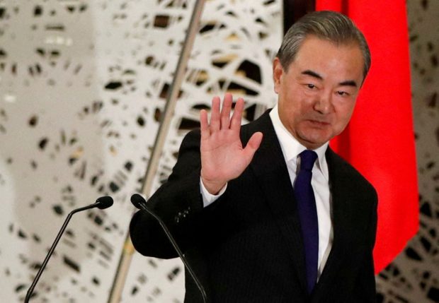 FILE PHOTO: China's State Councilor and Foreign Minister Wang Yi waves as he leaves a news conference in Tokyo, Japan, November 24, 2020. REUTERS/Issei Kato/Pool/File Photo