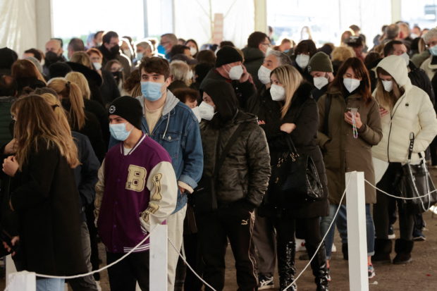 FILE PHOTO: People wait to receive coronavirus disease (COVID-19) vaccines inside the Mostra d'Oltremare vaccination centre in Naples, Italy, January, 8 2022. REUTERS/Ciro De Luca