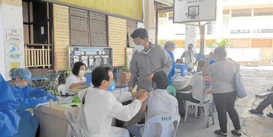 POPULATION PROTECTION As the Cebu City government limits the movement of the unvaccinated, residents continue to troop to COVID-19 vaccination centers, like this one set up at at a public school in Barangay Tisa. —NESTLE SEMILLA