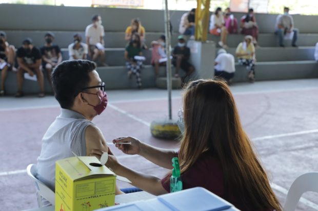 A resident of the City of San Fernando in Pampanga province gets vaccinated against COVID-19 via the village-based vaccination program