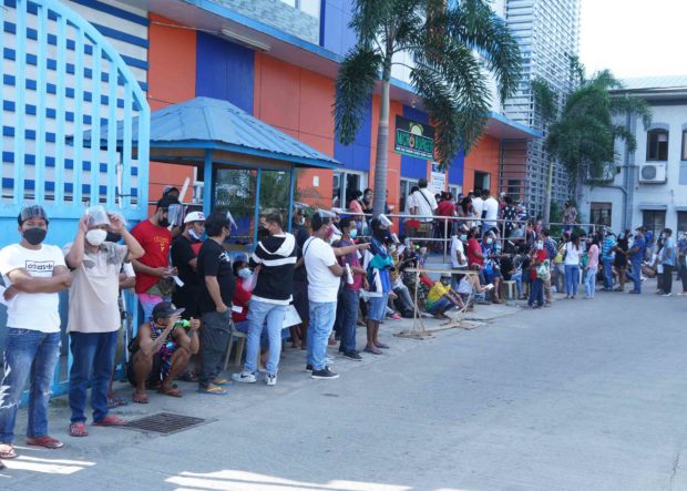 People queue for their first dose of the vaccine against COVID-19 outside the Region 1 Medical Center in Dagupan City. The city has recorded its first case of the highly contagious Omicron variant of COVID-19 through a returning overseas Filipino worker from the U.K. | PHOTO: Ray B. Zambrano