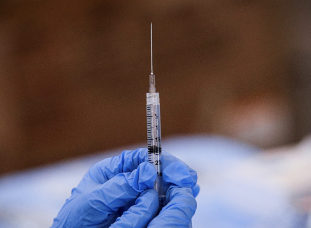 FILE PHOTO: A syringe is filled with a dose of Pfizer's coronavirus disease (COVID-19) vaccine at a pop-up community vaccination center at the Gateway World Christian C