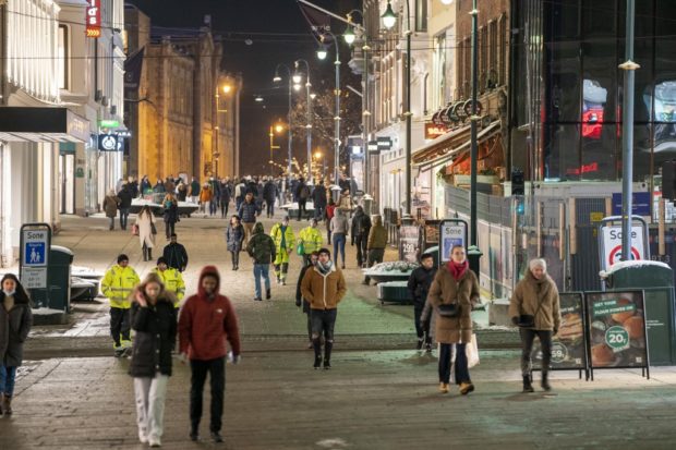 People walk along a pedestrian zone in Oslo on February 2, 2022 as the gastronomy reopens for guests. - Norway on February 1 announced it would scrap most of its Covid restrictions despite an Omicron-fuelled surge in infections, saying society must "live with" the virus. (Photo by Terje Pedersen / NTB / AFP) / Norway OUT