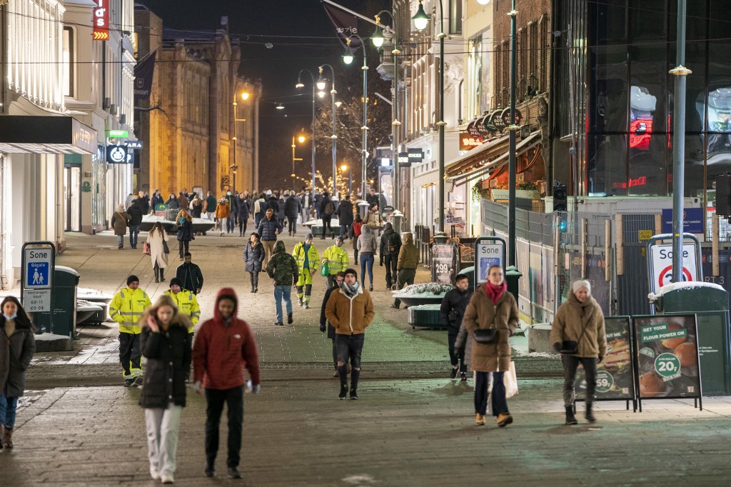 People walk along a pedestrian zone in Oslo on February 2, 2022 as the gastronomy reopens for guests. - Norway on February 1 announced it would scrap most of its Covid restrictions despite an Omicron-fuelled surge in infections, saying society must "live with" the virus. (Photo by Terje Pedersen / NTB / AFP) / Norway OUT norway social distancing lift COVID-19