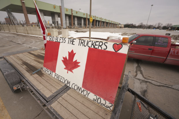 A trailer with a sign supporting the Freedom Convoy blocks the road near the Customs Inspection booths during a protest against Covid-19 vaccine mandates at the Ambassador Bridge border crossing, in Windsor, Ontario, on February 8, 2022. - The protestors, who are in support of the Truckers Convoy in Ottawa, have blocked traffic in the Canada bound lanes since Monday evening. Approximately $323 million worth of goods cross the Windsor-Detroit border each day at the Ambassador Bridge making it North Americas busiest international border crossing.022. (Photo by Geoff Robins / AFP)