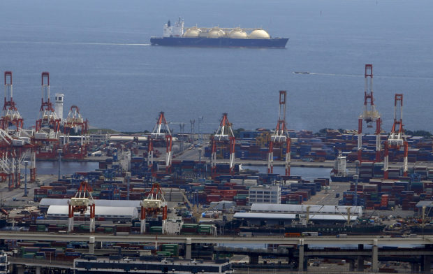 FILE PHOTO: A LNG (Liquefied Natural Gas) tanker is seen behind a port in Yokohama, south of Tokyo, Japan, September 4, 2015. REUTERS/Yuya Shino