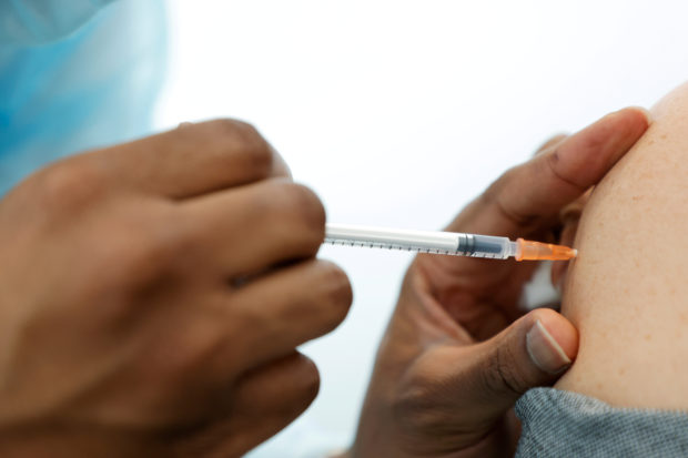 FILE PHOTO: A medical staff administers the Pfizer-BioNTech COVID-19 vaccine to a woman at a coronavirus disease (COVID-19) vaccination center in Neuilly-sur-Seine, France, February 19, 2021. REUTERS/Sarah Meyssonnier