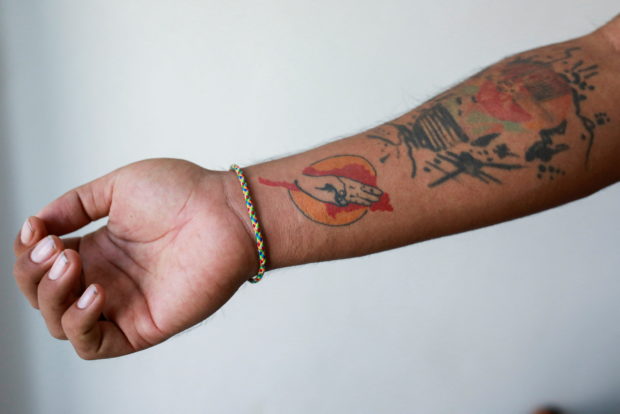 Lin Lin Bo Bo, whose parents cut ties with him, shows his tattoo to mark the Myanmar Spring revolution, at Thai-Myanmar border, January 26, 2022. REUTERS/Soe Zeya Tun