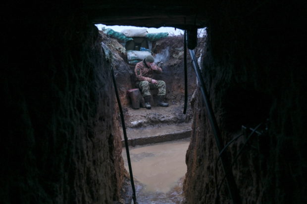A service member of the Ukrainian armed forces rests in a trench at combat positions near the line of separation from Russian-backed rebels outside the town of Svitlodarsk in the Donetsk region, Ukraine February 8, 2022. REUTERS/Maksim Levin