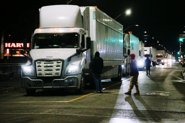 Trucks are backed up after protestors shut down the last entrance to the Ambassador Bridge, which connects Detroit and Windsor, as the protest against the coronavirus disease (COVID-19) vaccine mandates continues, in Windsor, Ontario, Canada February 9, 2022. REUTERS/Carlos Osorio