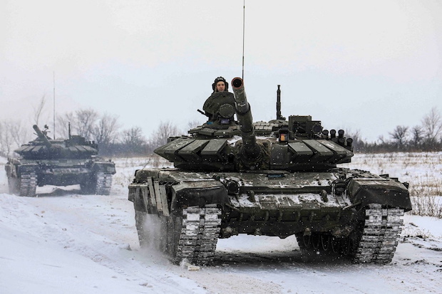 Photo of Russian servicemen in tanks for story: Russia says some troops pulling back from near Ukraine 