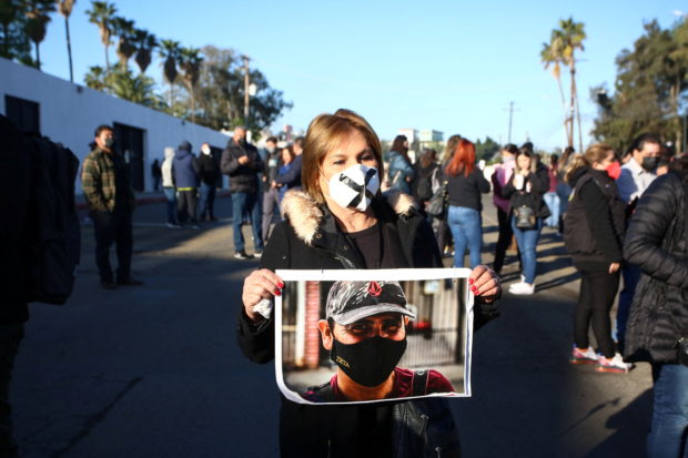 A journalist holds a photo of late photojournalist Margarito Martinez during a protest to demand justice for the violent deaths of five journalists this year, amid a new peak in attacks against press workers in the country, outside a military facility where Mexican President Andres Manuel Lopez Obrador holds his regular news conference, in Tijuana, Mexico February 17, 2022. REUTERS/Jorge Duenes