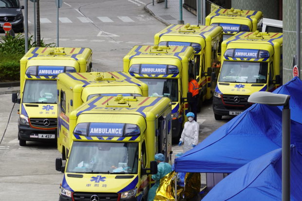 Medical workers and ambulances are seen outside Caritas Medical Centre in Cheung Sha Wan district, following the coronavirus disease (COVID-19) outbreak in Hong Kong, China February 18, 2022. REUTERS/Joyce Zhou