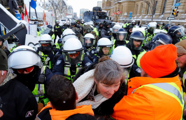 Canadian police advance push protestors back in front of Parliament Hill as police work to restore normality to the capital  as trucks and demonstrators continue to occupy the downtown core to protest COVID-19 restrictions in Ottawa, Ontario, Canada, February 19, 2022.  REUTERS/Patrick Doyle