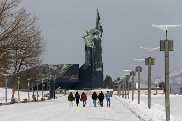 People walk towards a monument to the Liberators of Donbass in the rebel-held city of Donetsk, Ukraine January 27, 2022. REUTERS/Alexander Ermochenko