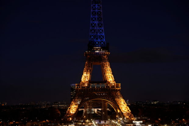 The Eiffel Tower is lit up in blue and yellow, the colours of the Ukrainian flag, in support of the Ukrainian people after Russia launched a massive military operation against Ukraine, in Paris, France, February 25, 2022. REUTERS/Benoit Tessier