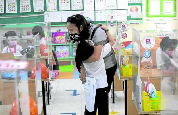 RESUMPTION OF PILOT FACE-TO-FACE CLASSES / FEBRUARY 9, 2022 A kindergarten pupil hugs teacher Nadinne Antaran as pilot face-to-face classes at Aurora Quezon Elementary School in San Andres, Manila resumes after a halt amid surge of COVID-19 due to Omicron variant. INQUIRER PHOTO / RICHARD A. REYES