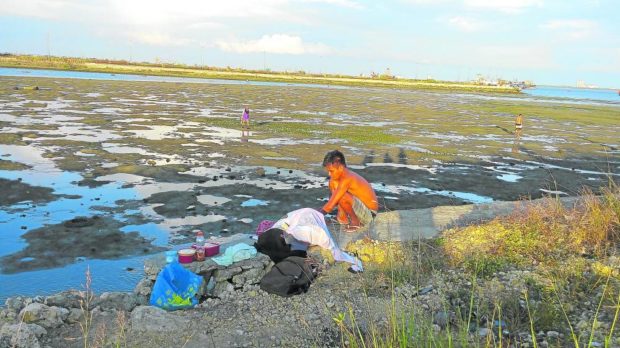 Photo of people at an area at low tide in Cebu for story: Reshaping Cebu