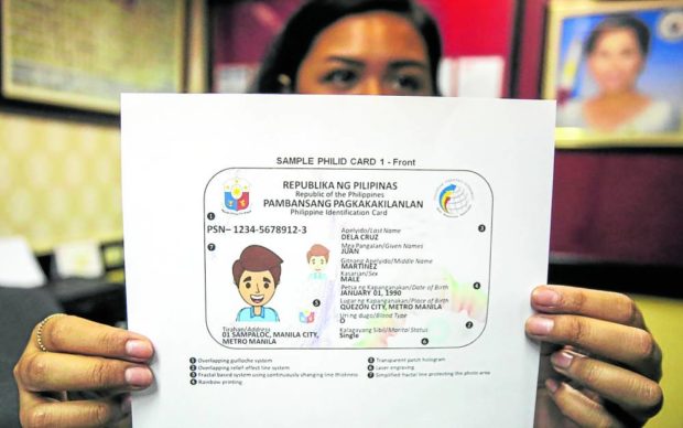 Photo of a government employee showing the new national ID, for story: Accept new national ID, Duterte orders gov’t, private offices