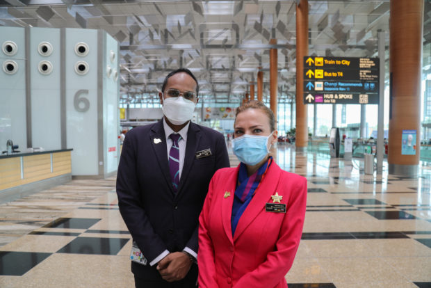 Front-line staff, identified by their gold pins, are trained to support passengers with invisible disabilities on their airport journey