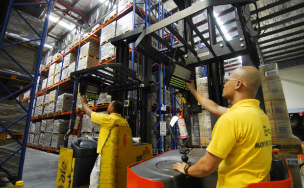 FILE PHOTO Workers check the inventory through a monitor attached to their forklifts inside a newly built product distribution warehouse in Cabuyao, Laguna. AFP PHOTO/JES AZNAR (Photo by JES AZNAR / AFP)