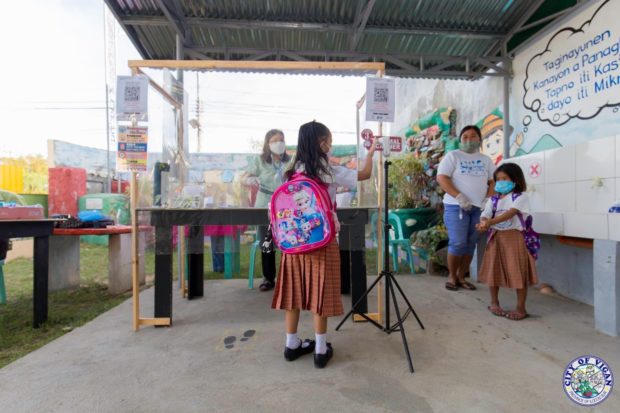 A pupil of an elementary school in Vigan City, Ilocos Sur has her temperature checked at a medical triage during the expanded in-person classes on Monday, Feb. 21. (Photo courtesy of Vigan City government)