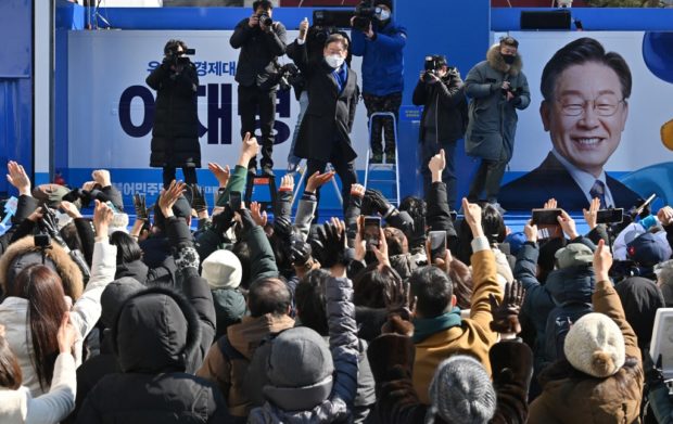 South Korean presidential candidate Lee Jae-myung (C) of the ruling Democratic Party gestures to his supporters during an election campaign in Seoul on February 16, 2022, ahead of the March 9 presidential election. (Photo by Jung Yeon-je / AFP)