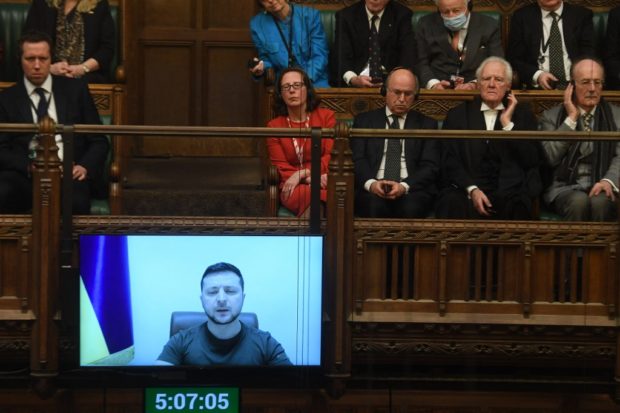 Ukraine's President Volodymyr Zelensky speaking before the UK Parliament through a live video-link in the House of Commons, in London, on March 8, 2022. - Ukraine's President Volodymyr Zelensky, invoking the wartime defiance of British prime minister Winston Churchill, vowed on March 8, 2022 to "fight to the end" in a historic virtual speech to UK lawmakers. "We will not give up and we will not lose," he said, recounting a day-by-day account of Russia's invasion that dwelt on the costs in lives of civilians including Ukrainian children. (Photo by JESSICA TAYLOR / various sources / AFP) / RESTRICTED TO EDITORIAL USE - NO USE FOR ENTERTAINMENT, SATIRICAL, ADVERTISING PURPOSES - MANDATORY CREDIT " AFP PHOTO / Jessica Taylor /UK Parliament"